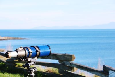 Close-up of camera on sea against sky