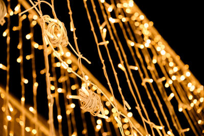 Low angle view of illuminated lights hanging at night