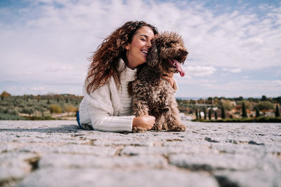 Woman lying down on floor with dog outdoors