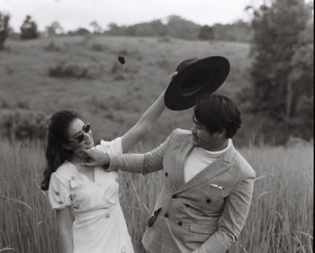 Siblings standing on field