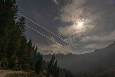 Scenic view of mountains against sky and airplane trails