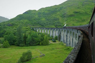 Scenic view of bridge and mountains against sky