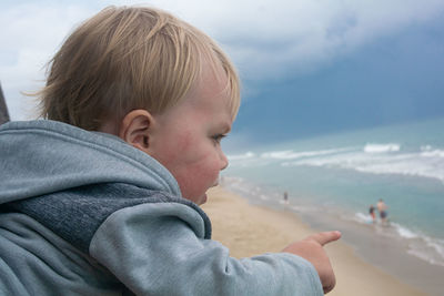 Portrait of boy on beach against sky