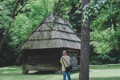 Man standing in front of old house at forest