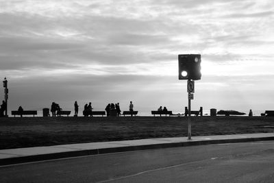 Group of people walking on road against sky