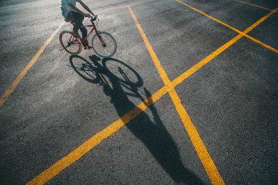 Low section of boy riding bicycle on road