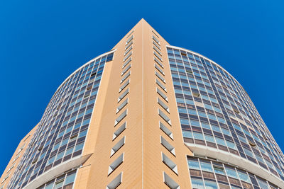 Low angle view of modern building against clear blue sky