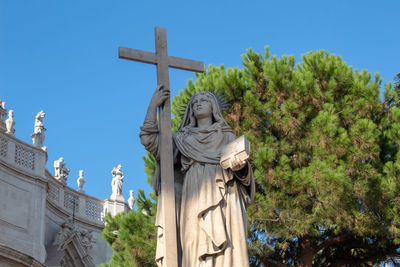 Low angle view of statue of a nun against sky