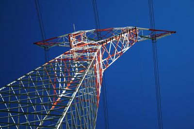 Low angle view of ferris wheel against clear blue sky