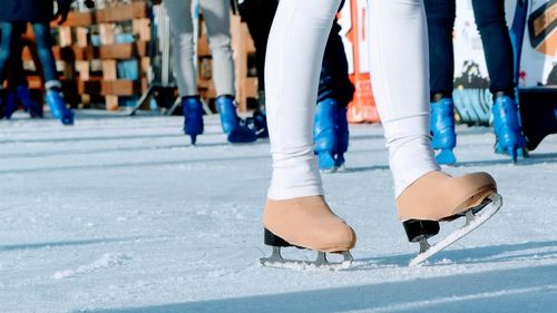 Low section of woman ice-skating on rink