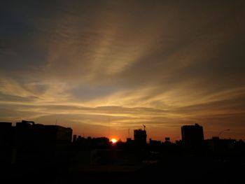 Silhouette cityscape against sky during sunset