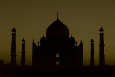 Silhouette of a famous monument, taj mahal with orange sky.