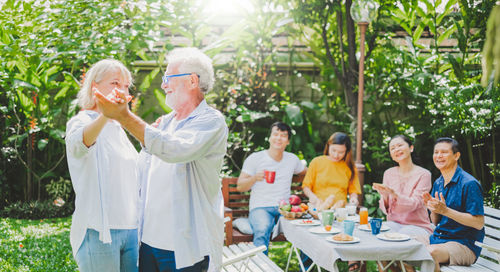 Cheerful family enjoying meal while sitting outdoors