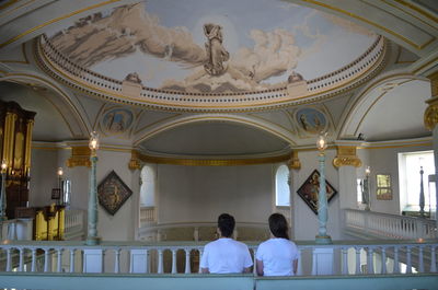 Couple in white sitting on chapel bench,  near lulworth castle, catholic stronghold in england, uk.