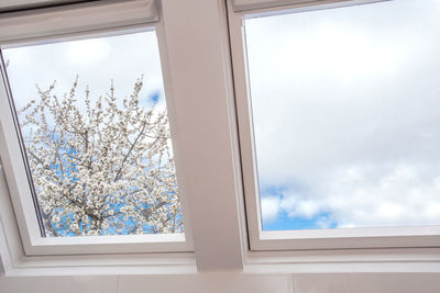 Low angle view of glass window against sky