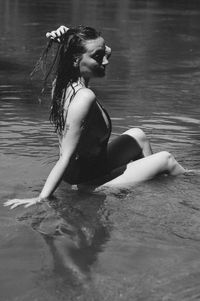 Sensuous woman sitting on sea shore at beach