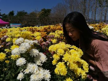 Young woman with yellow flowering plants