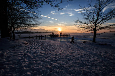 Scenic view of lakeshore against sky during winter