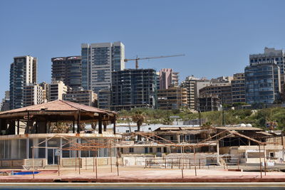 Buildings in city against clear blue sky