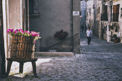 Man with flowers in front of building