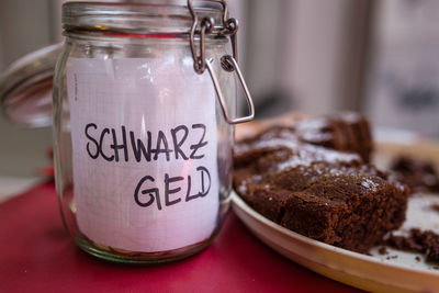 Close-up of cake in plate by jar on table