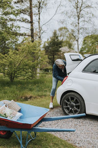 Woman standing in front of open car boot