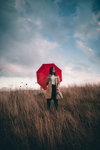 Woman standing on field against sky