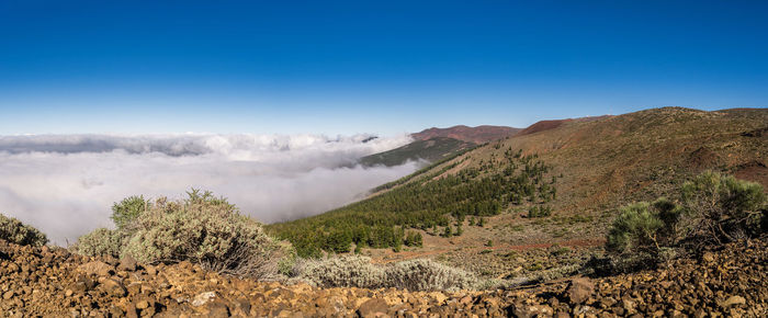 Scenic view of mountains against clear blue sky