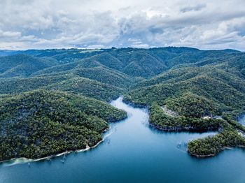 Aerial view of river amidst trees against sky