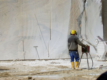 Rear view of man standing at construction site