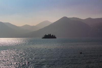 Scenic view of sea and mountains against clear sky