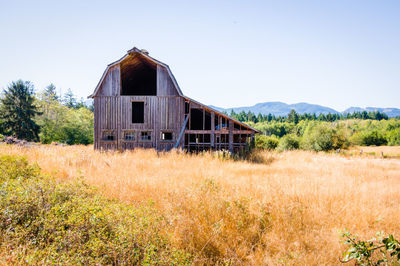 Abandoned built structure on field against clear sky