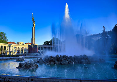 Panoramic view of fountain in city against sky