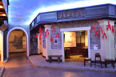 Illuminated restaurant by building at night