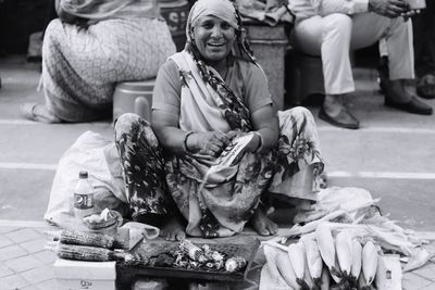 Full length of woman sitting in market