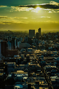 Illuminated cityscape against sky during sunset