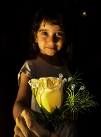 Close-up portrait of girl holding yellow flower