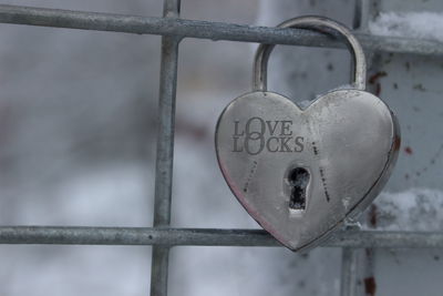 Close-up of love lock hanging on railing