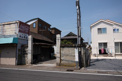 Road by buildings against sky in city