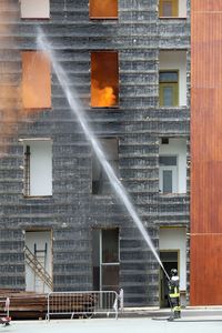 Fireman with the nozzle turns off the fire during an exercise in barracks