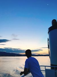 Rear view of man looking at sea against sky