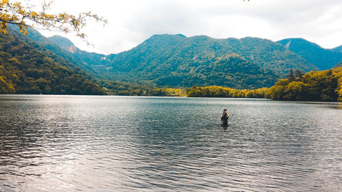 Scenic view of lake by mountains against sky