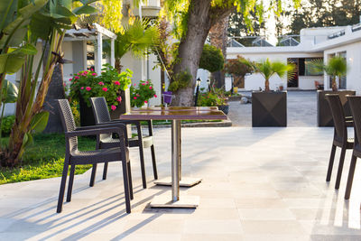 Empty chairs and tables in park against building