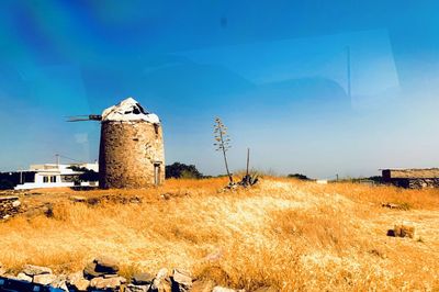 Abandoned tower on field against sky