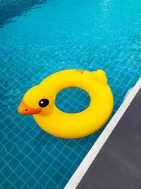 High angle view of yellow inflatable ring floating in swimming pool