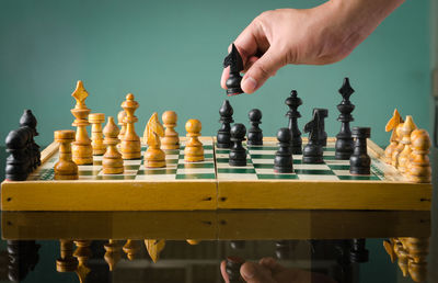 Cropped hand playing chess at home