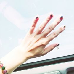 Close-up of woman hand against sky