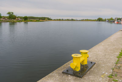 High angle view of yellow toy in lake against sky