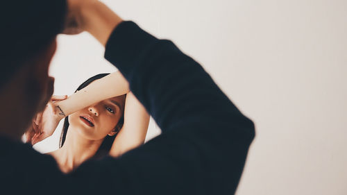 Portrait of woman holding camera over white background