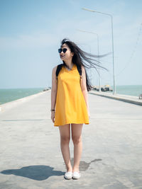 Woman standing on beach against sky